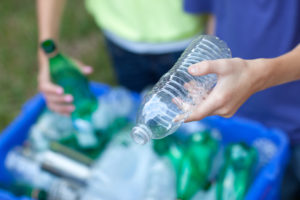 boy recycles plastic bottle for proper waste disposal
