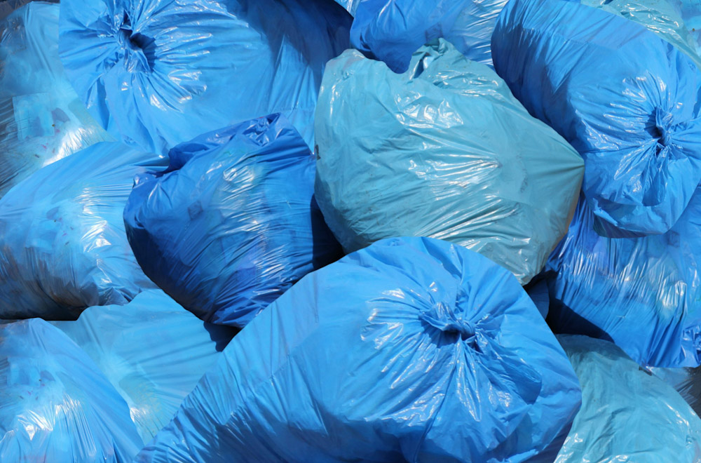 Blue bags of garbage piled high