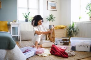 woman sorts clutter into different bins